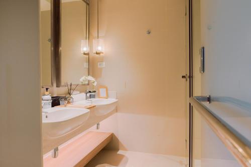 a bathroom with two sinks and a mirror and a tub at The Residences at Novotel Tower in Manila