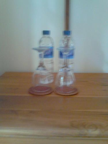 two bottles of water sitting on top of a wooden table at Pande Guest House in Pemuteran