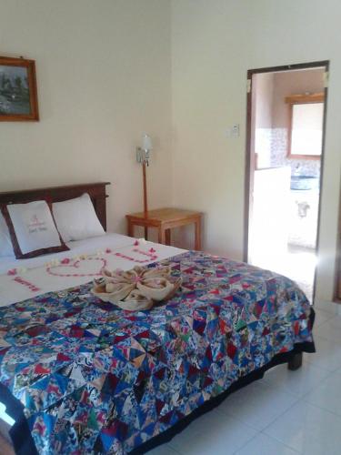 a bedroom with a bed with shoes on it at Pande Guest House in Pemuteran
