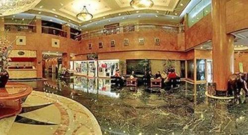 a large lobby with people sitting in chairs in a building at Golden Lustre Hotel in Shenzhen