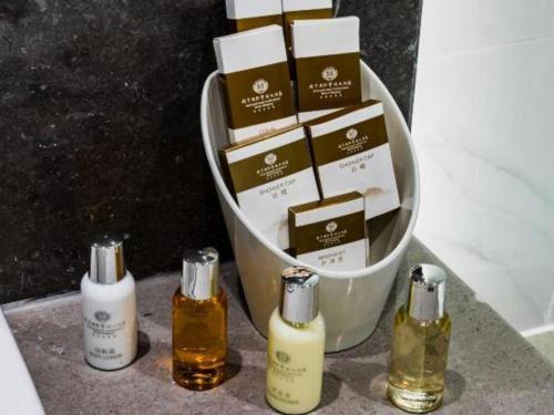 three bottles of essential oils on a counter next to a bucket at International Conference Hotel Nanjing in Nanjing