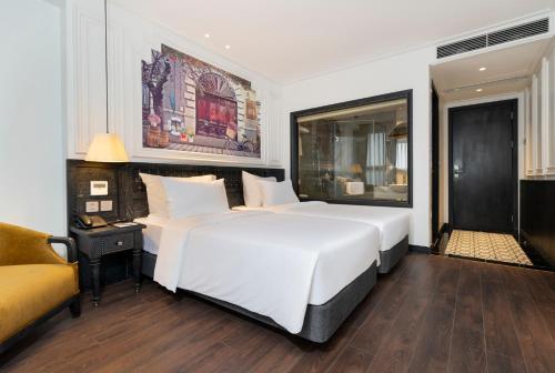 a bedroom with a large white bed and a couch at Luxe Paradise Premium Hotel and Spa in Hanoi