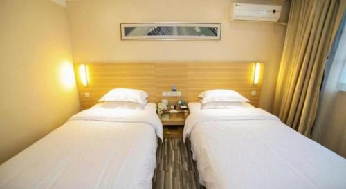 two beds in a hospital room with at City Comfort Inn Xiangyang Railway Station in Xiangyang