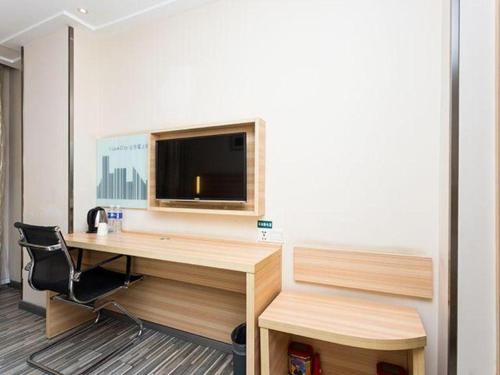 an office with a desk and a tv on a wall at City Comfort Inn Xiangyang Railway Station in Xiangyang