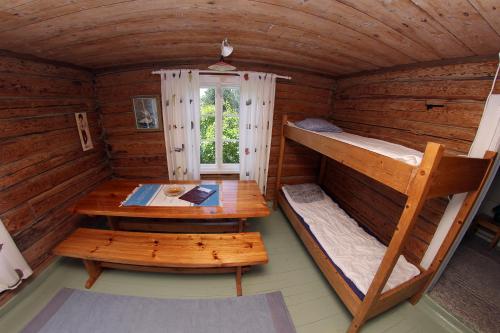 a room with two bunk beds and a table at Vuohensaari Camping Ahtela's cottage in Salo