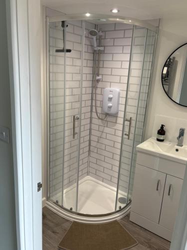 a glass shower in a bathroom with a sink at Katrins Nest in Southbourne
