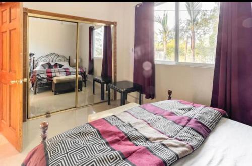 Un dormitorio con una cama y un espejo grande. en wonderful home WIFI high speed internet 20 minutes to Malibu beach, en Woodland Hills