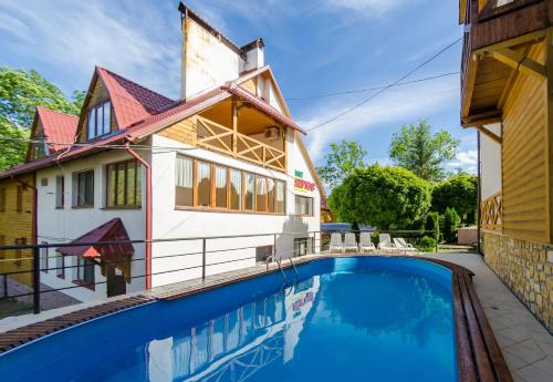 a house with a swimming pool in front of a house at Полярис Polyaris in Yaremche