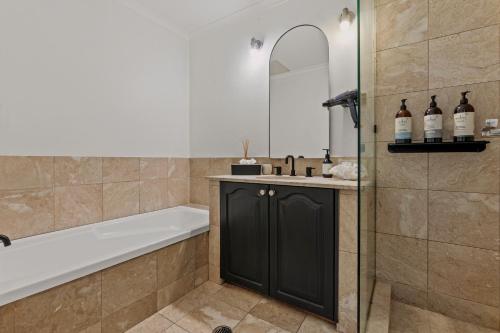 a bathroom with a bath tub and a sink at Sydney Harbourside Gem in Sydney