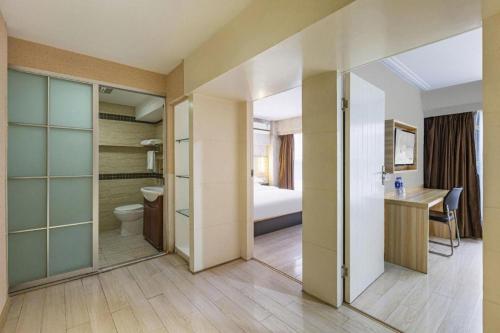 a room with a bathroom with a toilet and a bedroom at City Comfort Inn Wuhan Hankou Railway Station West Square in Wuhan