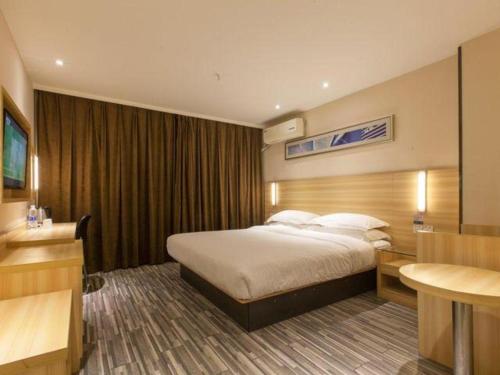 a hotel room with a bed and a desk at City Comfort Inn Wuhan Hankou Railway Station West Square in Wuhan