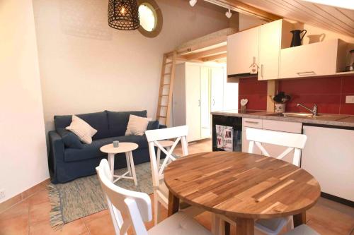 a kitchen and living room with a table and a couch at Nid douillet vaudois avec mezzanine in Bussigny