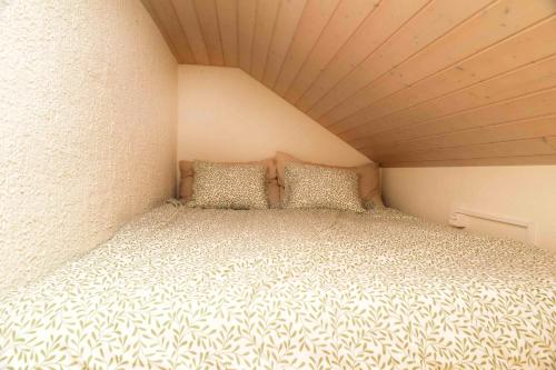 a large bed in a small room in a small room at Nid douillet vaudois avec mezzanine in Bussigny