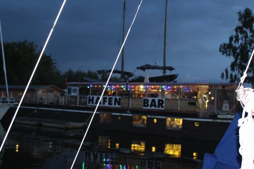 a boat with christmas lights on it in the water at Halbinsel Resort Peenemünde in Peenemünde