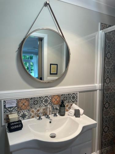 a bathroom with a sink and a mirror at Mitta Glen Guesthouse in Flaxton