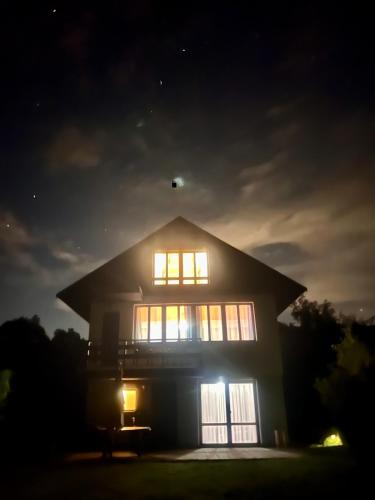 a house lit up at night with the lights on at Chata Roda s vnitřní saunou in Rabyně