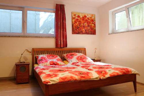 ein Schlafzimmer mit einem Bett und zwei Fenstern in der Unterkunft Großzügige Souterrainzimmer in München