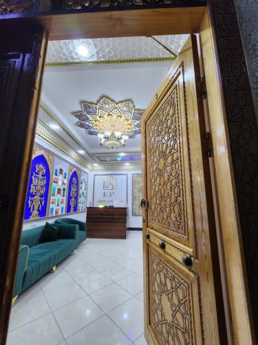 a door in a room with a couch and a chandelier at RAY Boutique Hotel in Bukhara