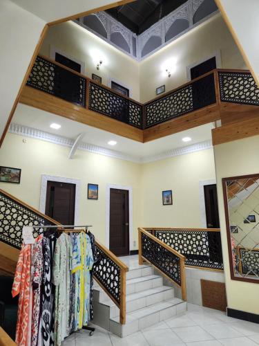 a room with stairs with clothes on racks at People Tours Bukhara in Muruntau