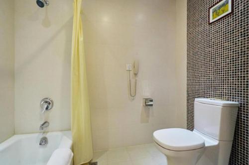 a bathroom with a white toilet and a shower at Huangshan International Hotel in Huangshan