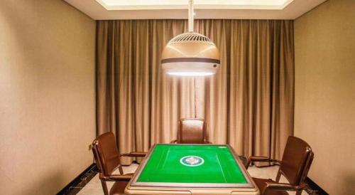 a conference room with a green table and chairs at Lavande Hotel Zhaoqing government Dinghu Mountain Scenic Spot in Zhaoqing