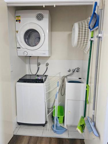 a laundry room with a washing machine and a washer at Large Pool Newly Renovated Apartment Walk to Whale watching and beaches in Urangan