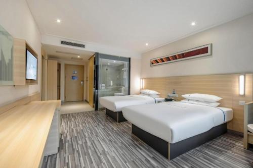 una camera d'albergo con due letti e una cabina doccia di City Comfort Inn Hechi Du'an Wenti Square a Du’an