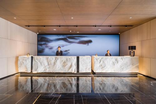 two men standing in front of a screen in a building at Shanghai Yunhe Yebo Hotel, Wuning Road Global Harbor Branch in Shanghai