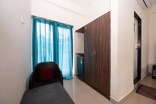 a room with a couch and a window with blue curtains at Hotel Baga inn in Baga