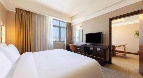 a hotel room with a bed and a television at Best Western Plus Fuzhou Fortune Hotel in Fuzhou
