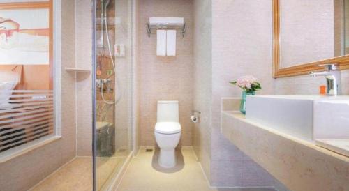 a bathroom with a toilet and a sink and a shower at Vienna International Shenzhen Tianan Digital City in Shenzhen