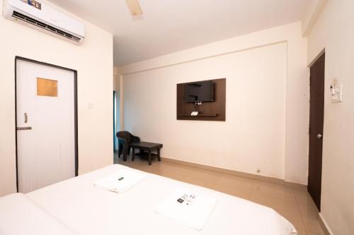 a bedroom with two beds and a tv on the wall at Hotel Baga inn in Baga