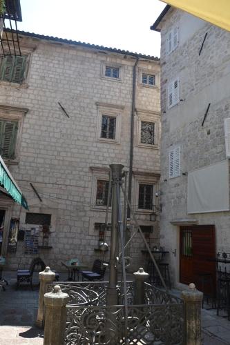 a stone building with a gate in front of it at Apartmani Art Karampana in Kotor