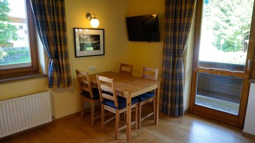 a dining room with a table and chairs and a television at Pension Dachsteinhof in Ramsau am Dachstein