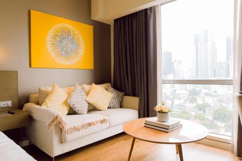 a living room with a couch and a table at The Residences at Novotel Tower in Manila