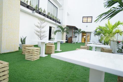 a courtyard with white tables and green grass at A79 Hotel in Chennai