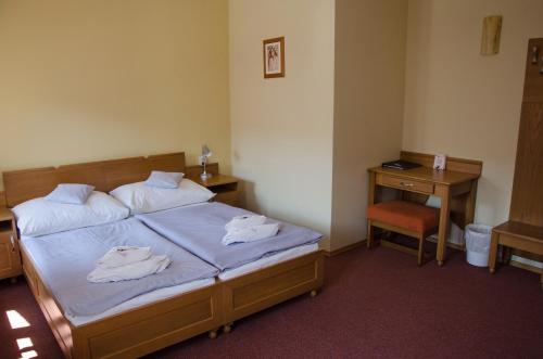 a bedroom with a bed with towels on it at Penzion Nad Oborou in Hradec Králové