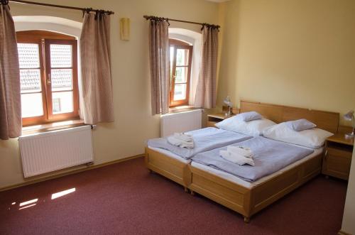 a bedroom with a bed with two towels on it at Penzion Nad Oborou in Hradec Králové
