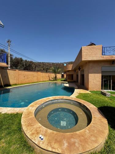 a swimming pool in front of a building at Dar NFis Suites et chambres de luxe dans un havre de paix vue paradisiaque au bord du lac in Lalla Takerkoust