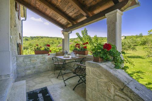 a patio with a table and chairs on a stone wall at Villa Angela e Giovanni in Vižinada