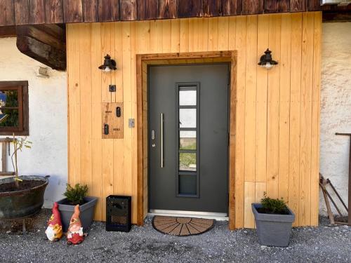 a front door of a house with potted plants at Appartements Ehrensberger in Brixen im Thale