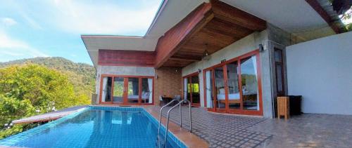 a house with a swimming pool in front of a house at Baan View Talay Pool Villas in Thong Nai Pan Yai