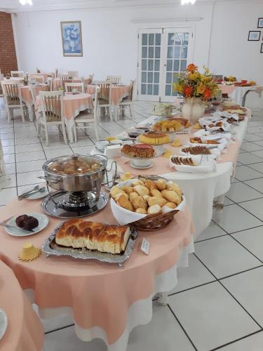 ein langer Tisch voller Essen auf Tischen in einem Raum in der Unterkunft Grand Ville Hotel in São Lourenço
