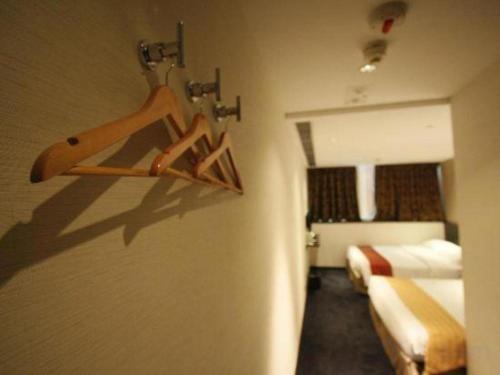a room with a bedroom with a bed and a closet at Noble Park Hotel in Hong Kong