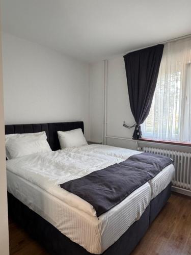 a large bed in a bedroom with a window at Pension Fürsteneck in Bad Arolsen