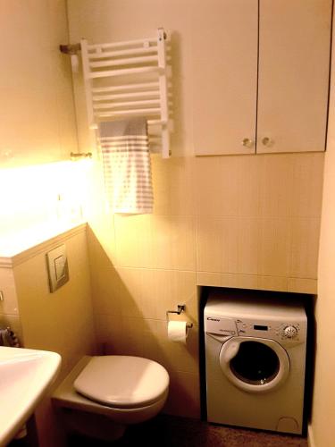 a bathroom with a toilet and a washing machine at Atelier Aleksandry in Gdynia