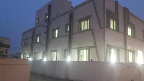 a building with its lights on in the night at Al Noor Saadah Furnished Apartments in Salalah