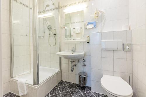 a bathroom with a sink and a toilet and a shower at Hotel West an der Bockenheimer Warte in Frankfurt/Main