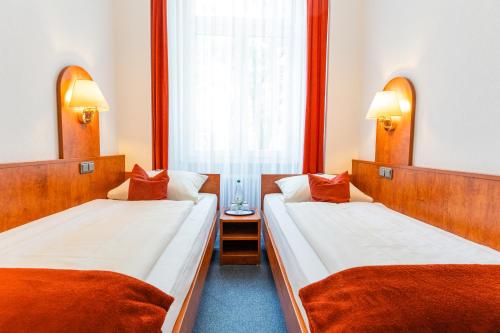 a hotel room with two beds and a window at Hotel West an der Bockenheimer Warte in Frankfurt/Main