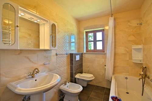 a bathroom with a sink and a toilet and a tub at Villa Angela e Giovanni in Vižinada